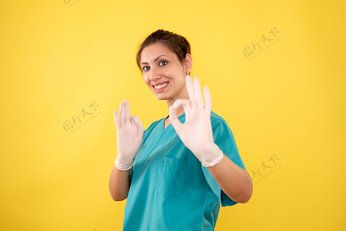 成人前视图黄色背景上戴手套的女医生病毒人黄色
