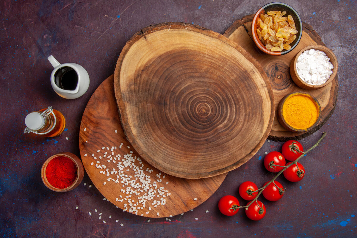 不同顶视图不同的调味料配上番茄上深色背景的饭菜调味料辛辣番茄木勺景观