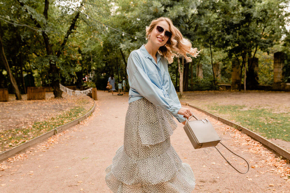 情感迷人的金发微笑坦率的女人挥舞着长发在公园里散步的乐趣在夏天的服装快乐肖像穿着