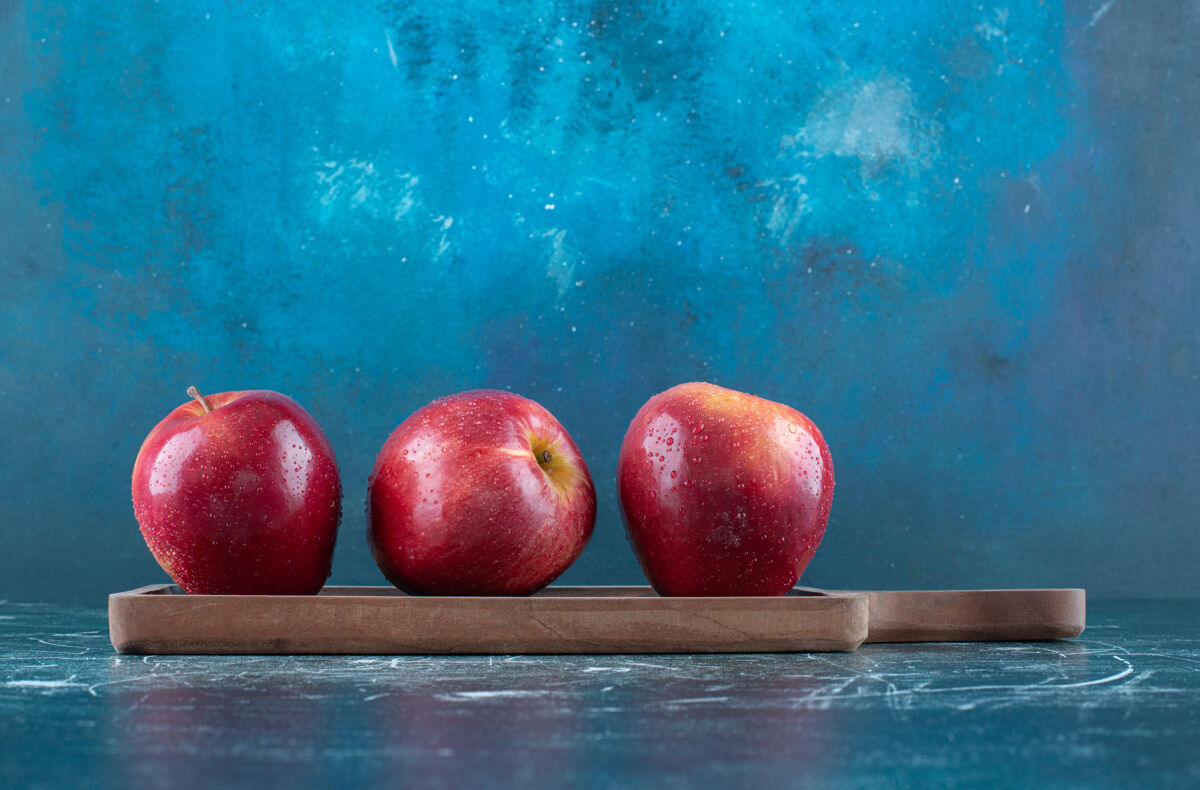 成熟整个红苹果放在木板上新鲜味道生的