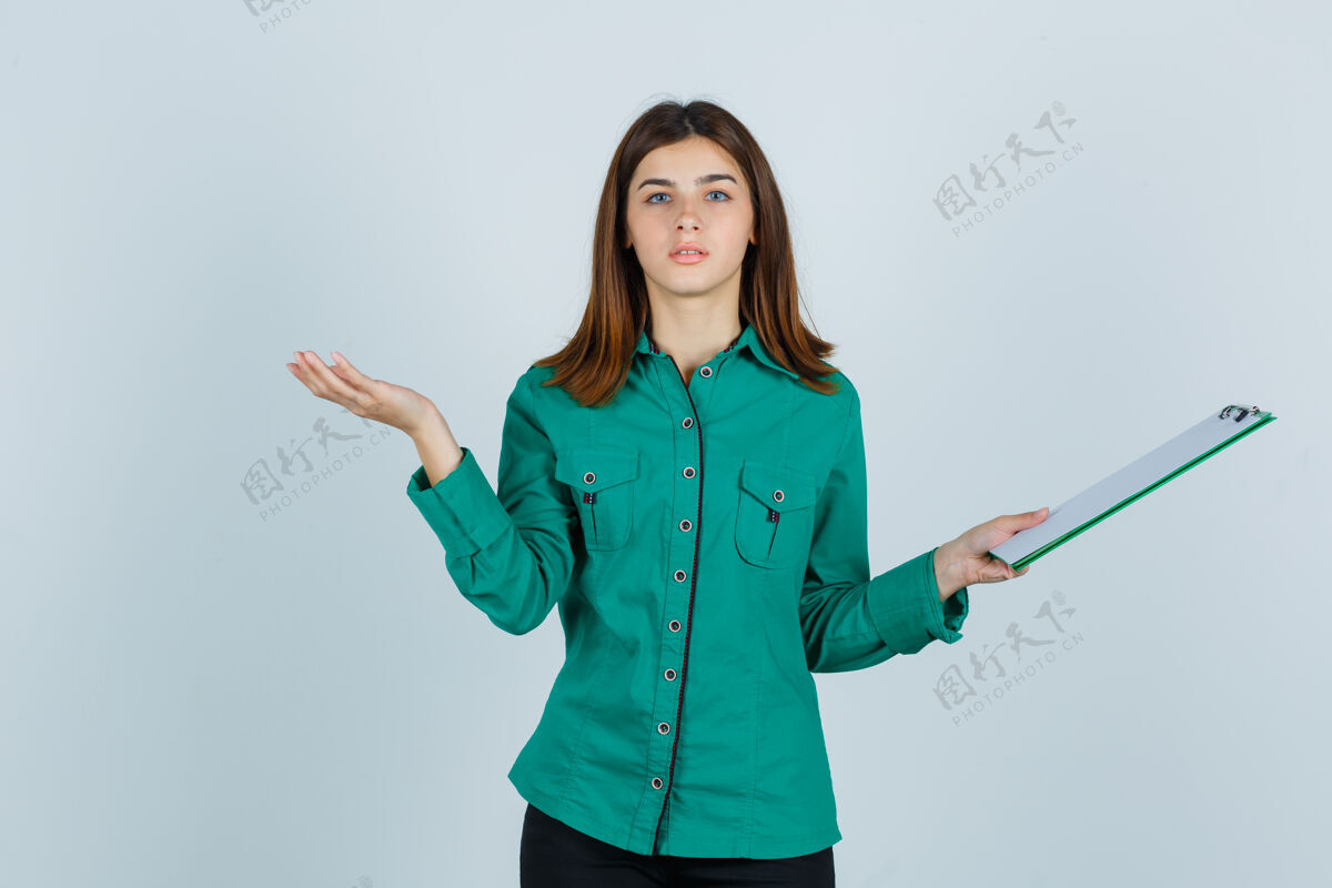 姿势年轻女孩穿着绿色上衣 黑色裤子拿着剪贴板 摊开手掌 严肃地看着前方蔓延衬衫表情