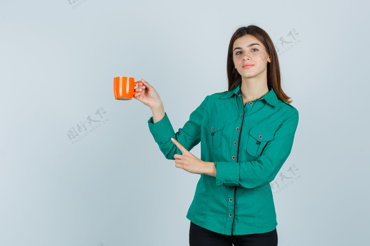 抱着穿着衬衫的年轻女士手里拿着一杯橘黄色的茶 指着左上角 看上去很自信 正对着前方女人干净指点