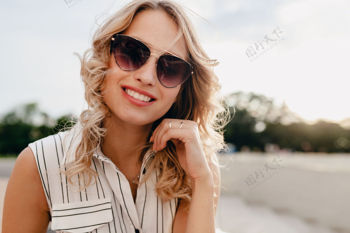 脸城市街道上一位年轻迷人的时尚金发女郎的特写肖像 穿着夏季时尚的连衣裙 戴着太阳镜护理积极女人