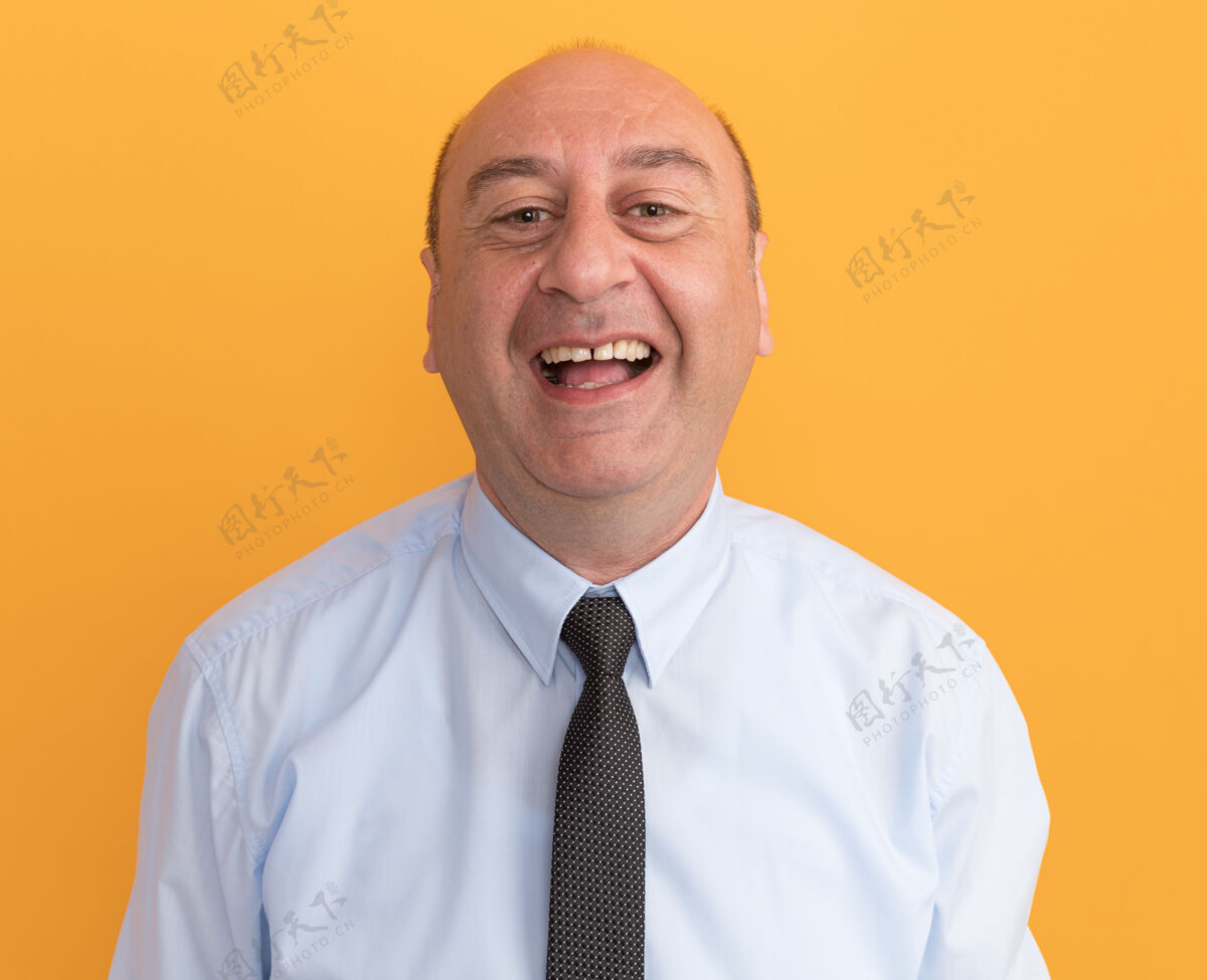 笑笑着的中年男子穿着白色t恤 打着领带 隔离在橙色的墙上穿中年领带