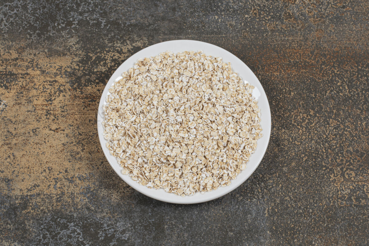燕麦美味的燕麦片放在白色盘子里农业水平卷燕麦
