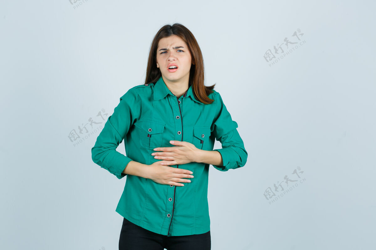 健康穿着绿色衬衫的漂亮小姐感觉胃痛 看起来不舒服 正面视图不快乐寒冷女性