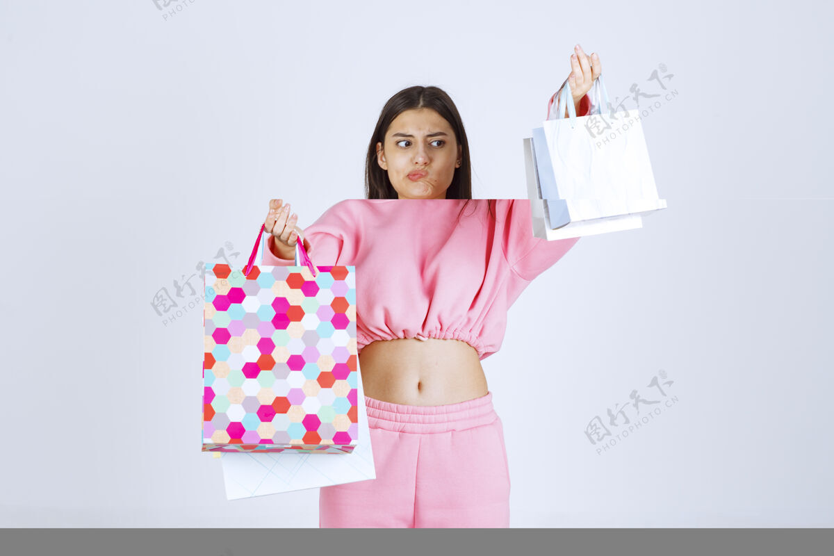 消极带着五颜六色购物袋的女孩看起来很不满意聪明女性成人