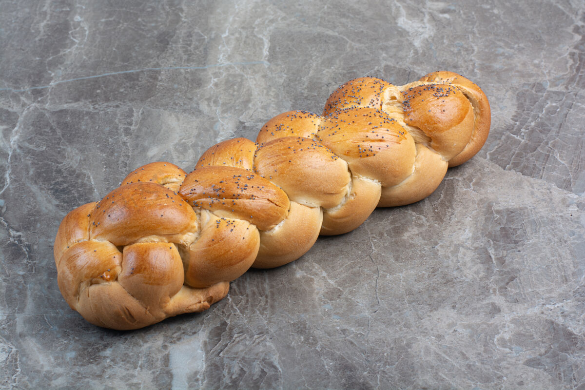 面包房大理石背景上有罂粟籽的新鲜面包新鲜糕点食物
