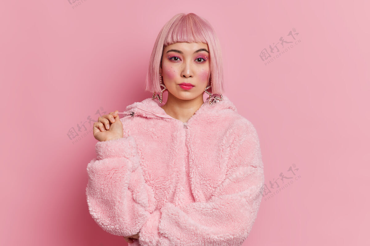 女性严肃漂亮的亚洲女人 一头时髦的粉色头发 穿着冬衣 妆容鲜艳生动冷淡奢华姿势