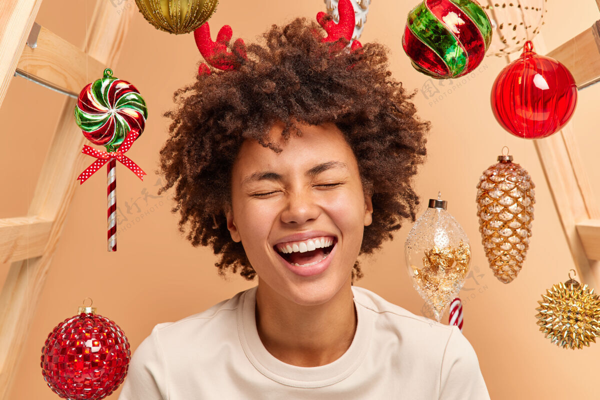 圣诞饰品一个过度运动的卷发女人的特写照片 她笑容灿烂 牙齿洁白 穿着休闲的驯鹿角卷发乐观角