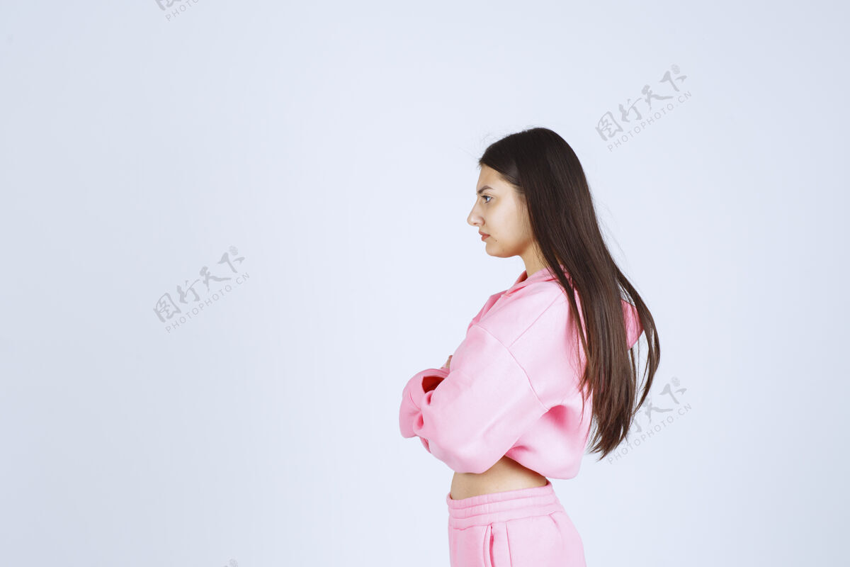 年轻人穿粉红色睡衣的女孩交叉双臂 看起来很有侵略性不安愤怒人