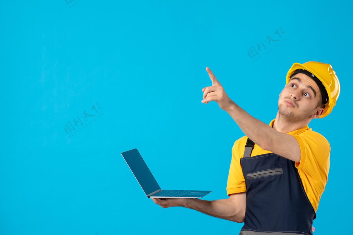 男工人穿着制服的男工人的正视图 笔记本电脑指向蓝色笔记本电脑表面服务