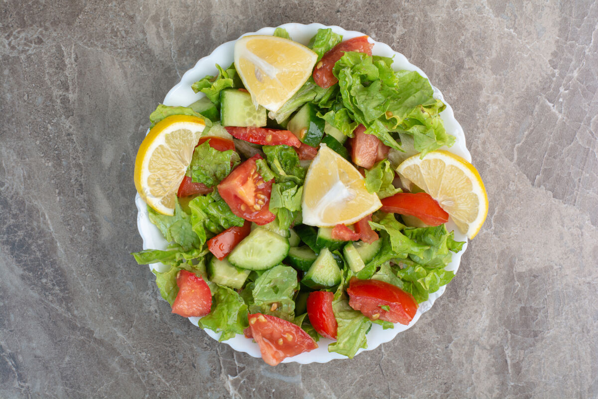 美食蔬菜沙拉加柠檬片放在白色盘子里盘子营养沙拉
