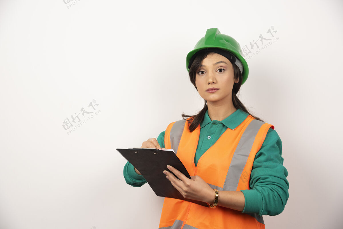 建筑穿着制服的女工业工程师 白色背景上有剪贴板女性工程师安全帽