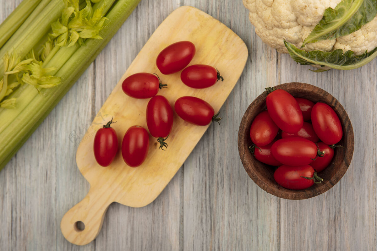 营养新鲜西红柿放在木制厨房板上的顶视图 西红柿放在木制碗上 花椰菜和芹菜被隔离在灰色的木制表面上芹菜膳食番茄