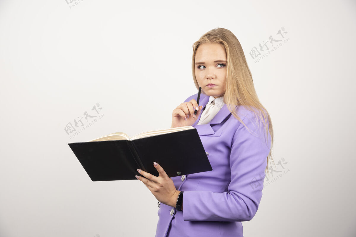 女士一个体贴的女人拿着白墙上打开的写字板女性模型平板电脑