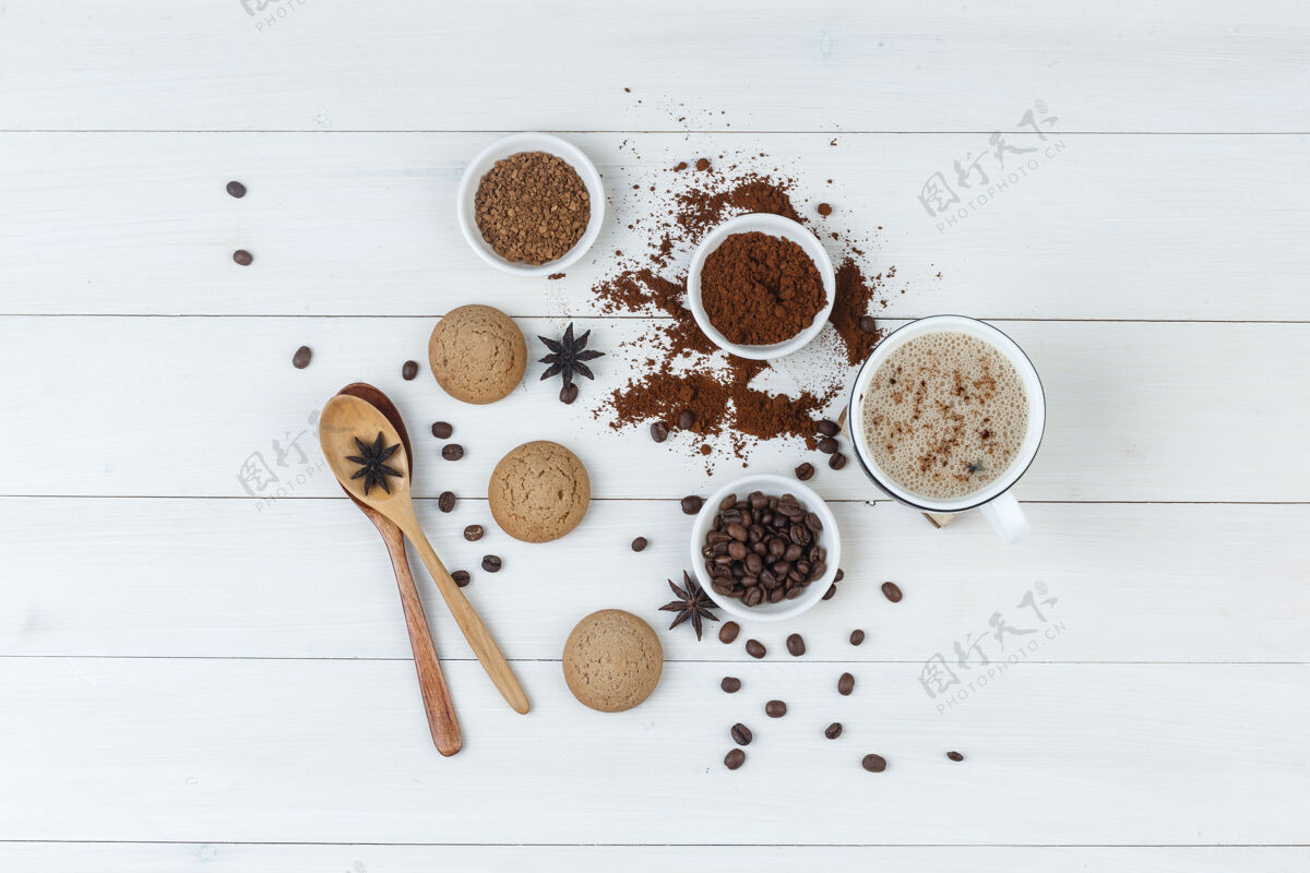 自然顶视图咖啡杯 咖啡豆 磨碎的咖啡 香料 饼干 木制背景上的木制勺子水平粗麻布桌子热