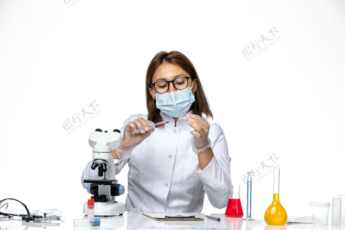 女医生前视图：女医生穿着白色医疗服 戴着面罩 因为在浅白色空间注射套装防护罩病毒