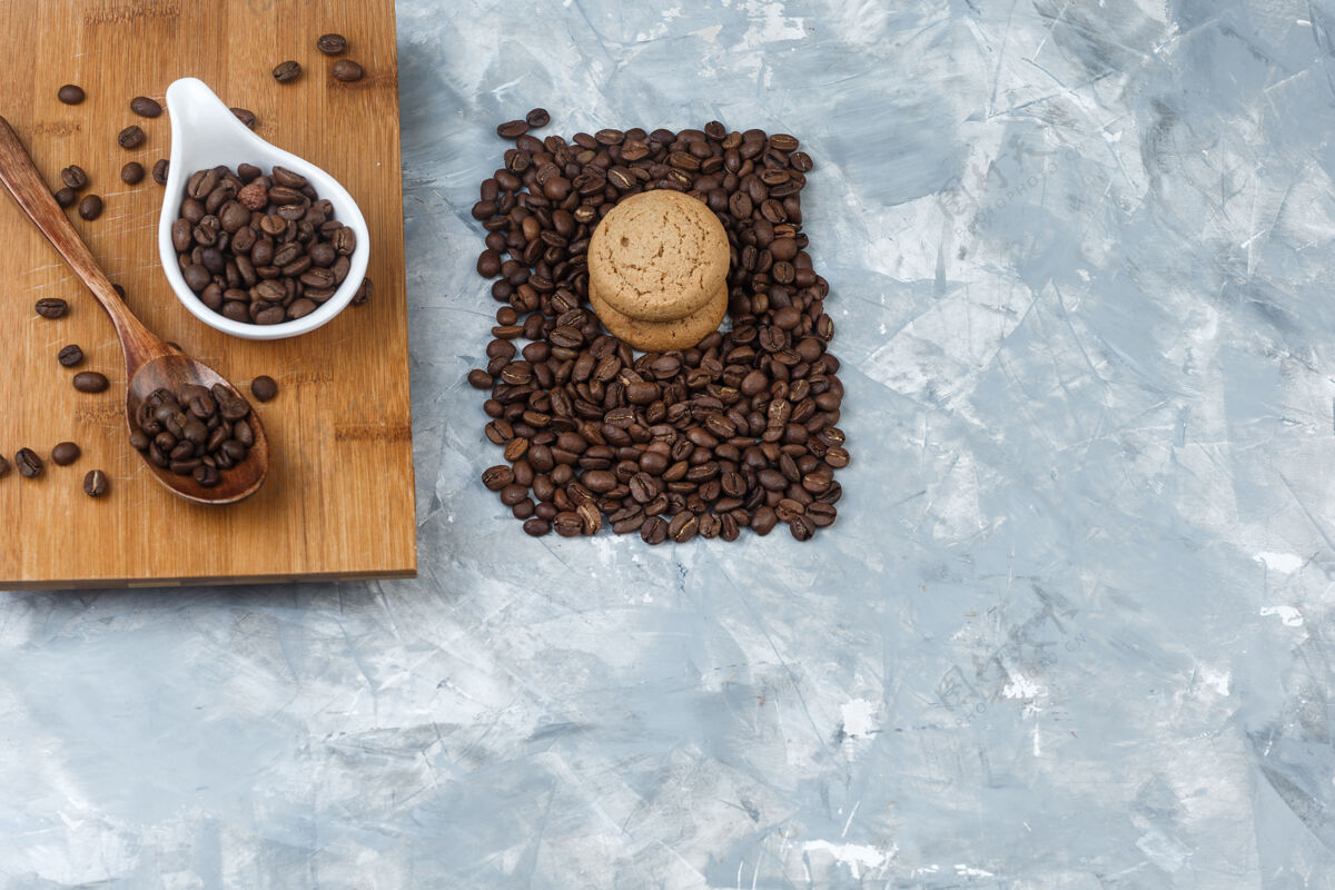 早餐平放咖啡豆 木勺放在砧板上 饼干放在浅蓝色大理石背景上水平水平咖啡卡布奇诺
