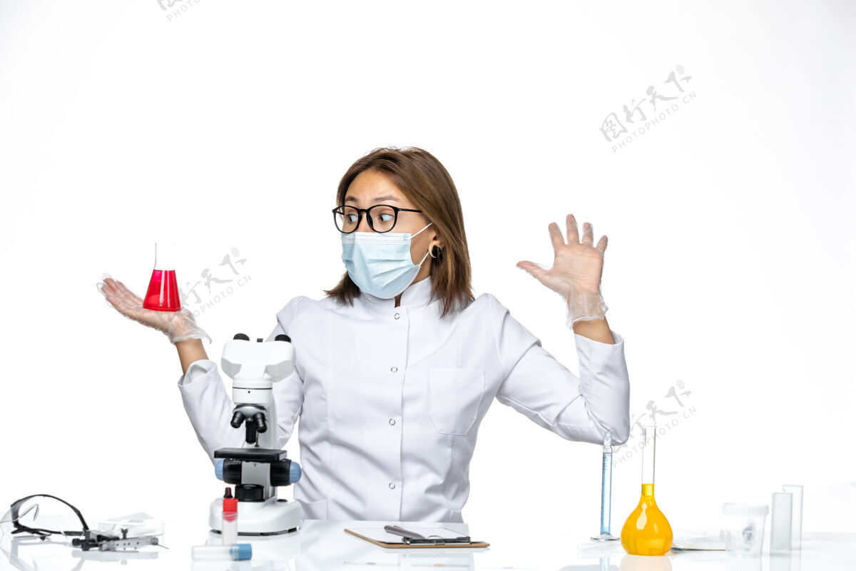 工作前视图：女医生穿着白色医疗服 戴着面罩 因为科维德在白色空间上使用解决方案大流行到期病毒