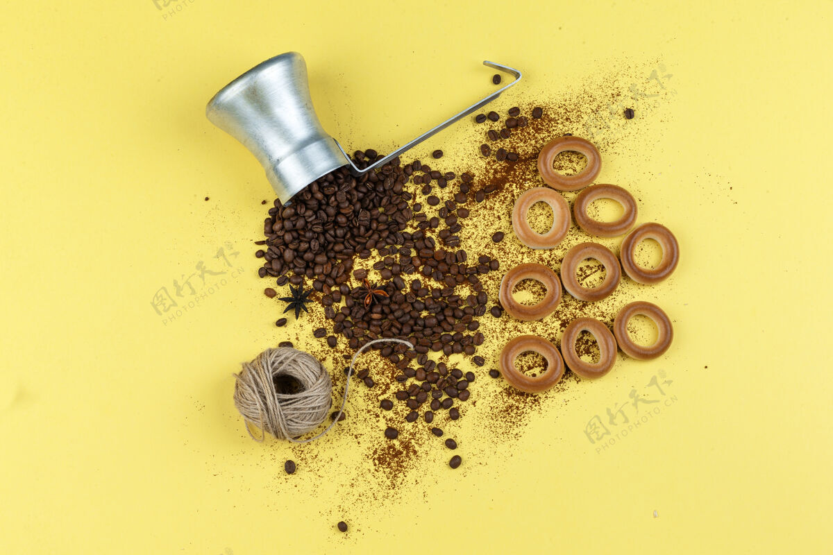 蛋糕咖啡豆在一个装有年糕 绳子 馒头的罐子里平放在黄色的背景上豆子种子杯子