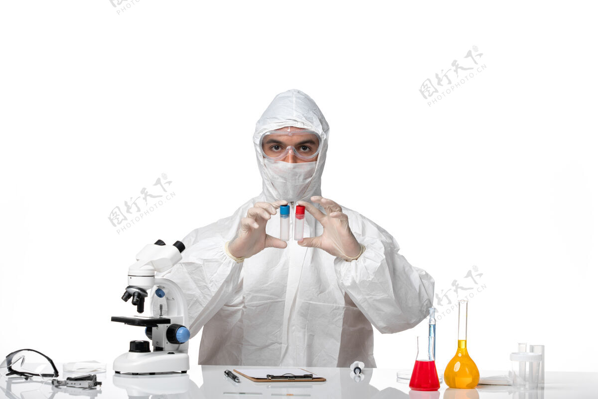 实验室正面图：男医生穿着防护服 戴着面罩 因为covid在一个空白处拿着烧瓶男医生化学工作