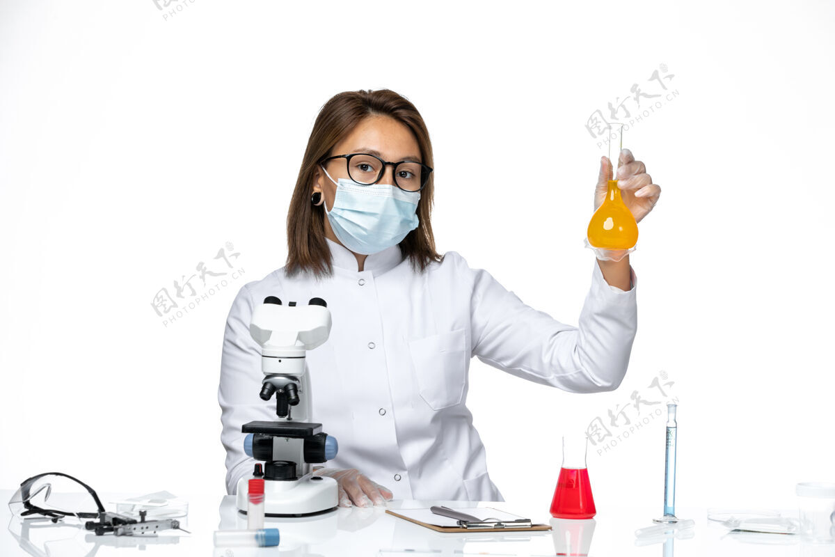 药品正面图：女医生穿着白色的医疗服 戴着口罩 坐在白色的办公桌上办公桌解决方案套装