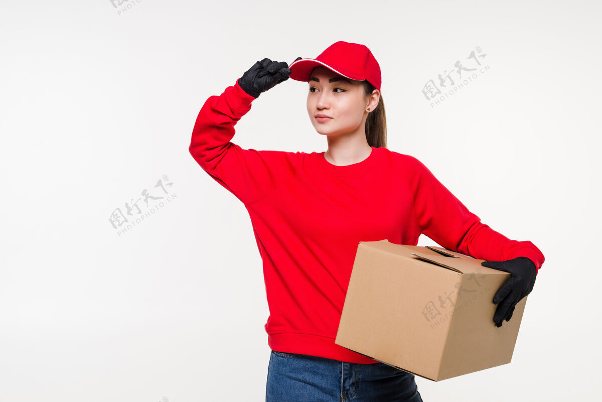年轻人年轻的亚洲女人 穿着制服 拿着一个盒子 带着迷人的微笑持有信息房子