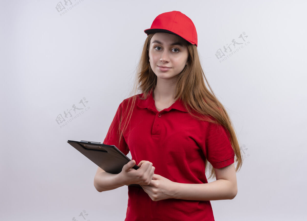制服穿着红色制服的年轻送货女孩拿着剪贴板 站在孤零零的白墙上女孩年轻拿着
