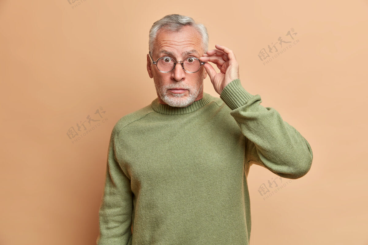 惊呆拍到惊愕的老者透过眼镜盯着反应意外的消息惊呆了摆出不安的姿势对着米色的墙壁穿休闲服沮丧反应镜头