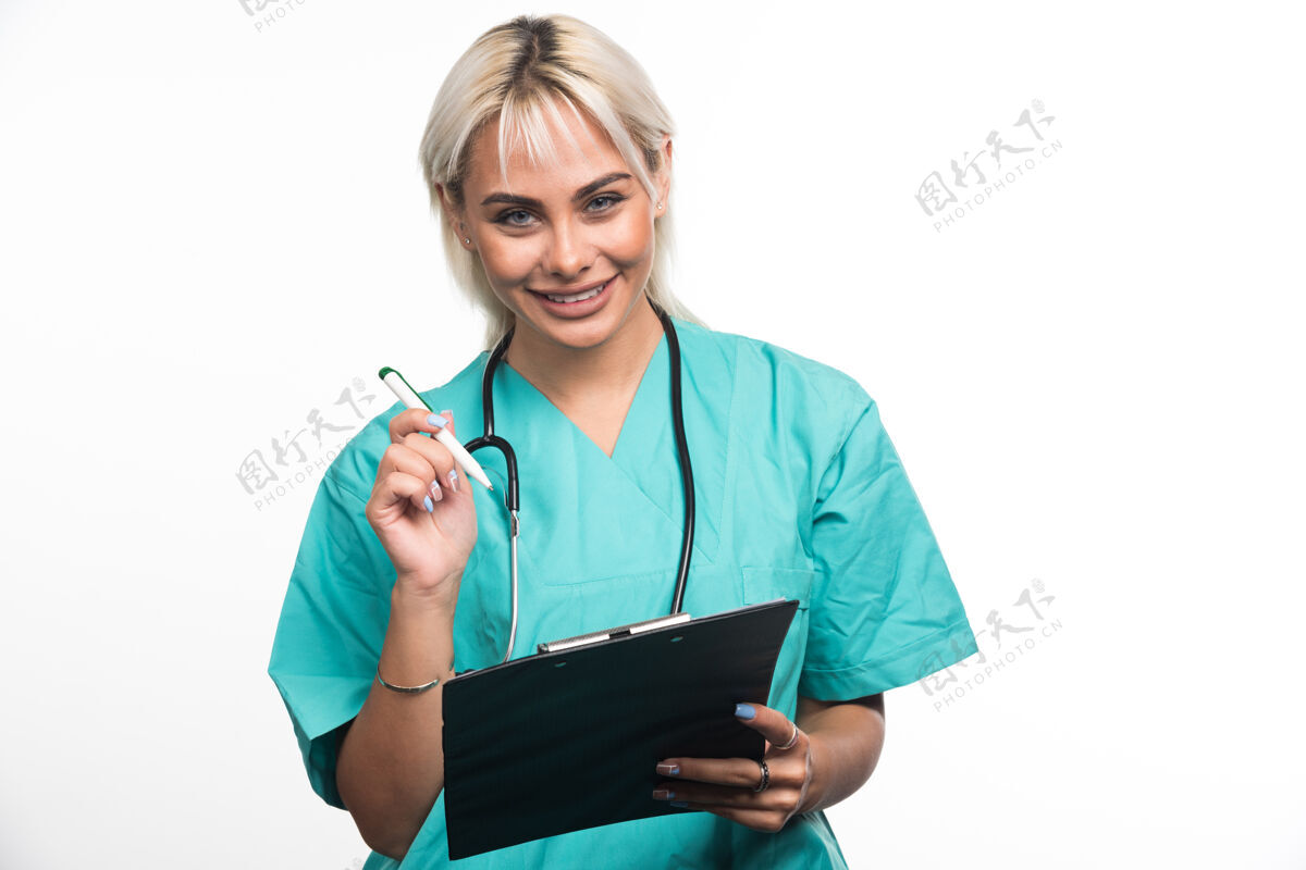 女性女医生用白纸笔在剪贴板上写东西女士医疗听诊器