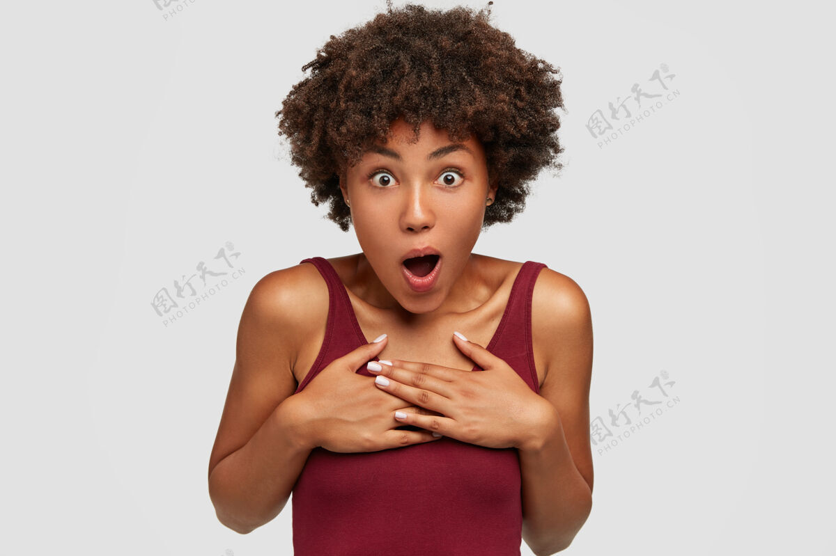 情绪照片中 情绪激动的黑皮肤年轻女性双手放在胸前 惊讶得喘不过气来射击水平惊呆了