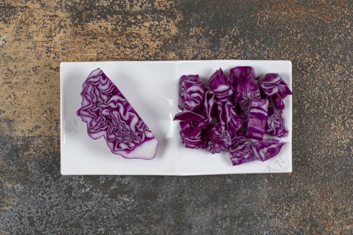 新鲜一块卷心菜放在旁边切碎的卷心菜碗里 放在大理石表面蔬菜红卷心菜美味