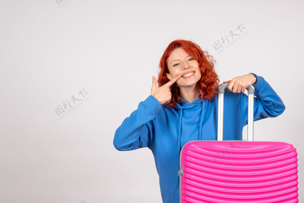 航程年轻女游客的正面图 白色墙壁上有粉红色的包成人女士肖像