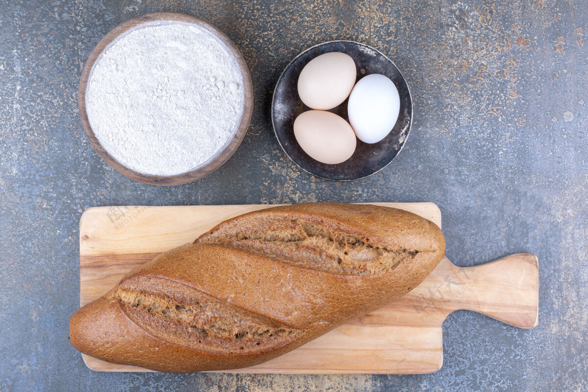 配料把面包放在面粉碗上 鸡蛋放在大理石表面指挥棒碗芝麻