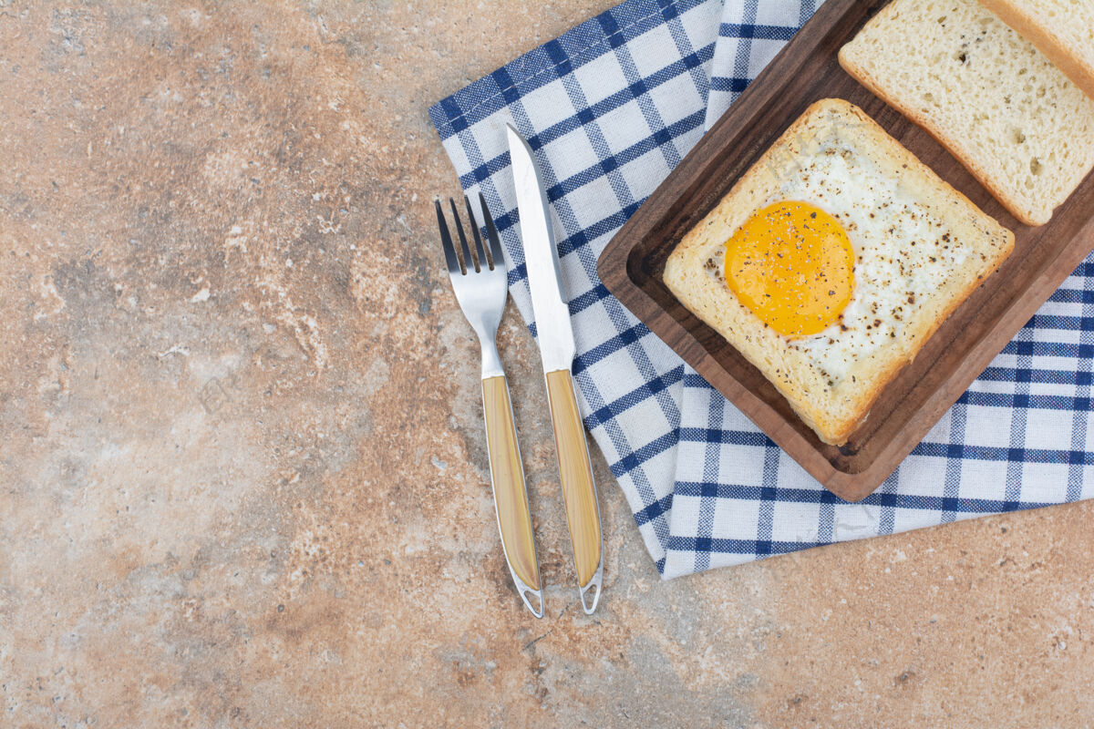 鸡蛋木盘上放有香料的鸡蛋吐司和餐具面包房新鲜餐具