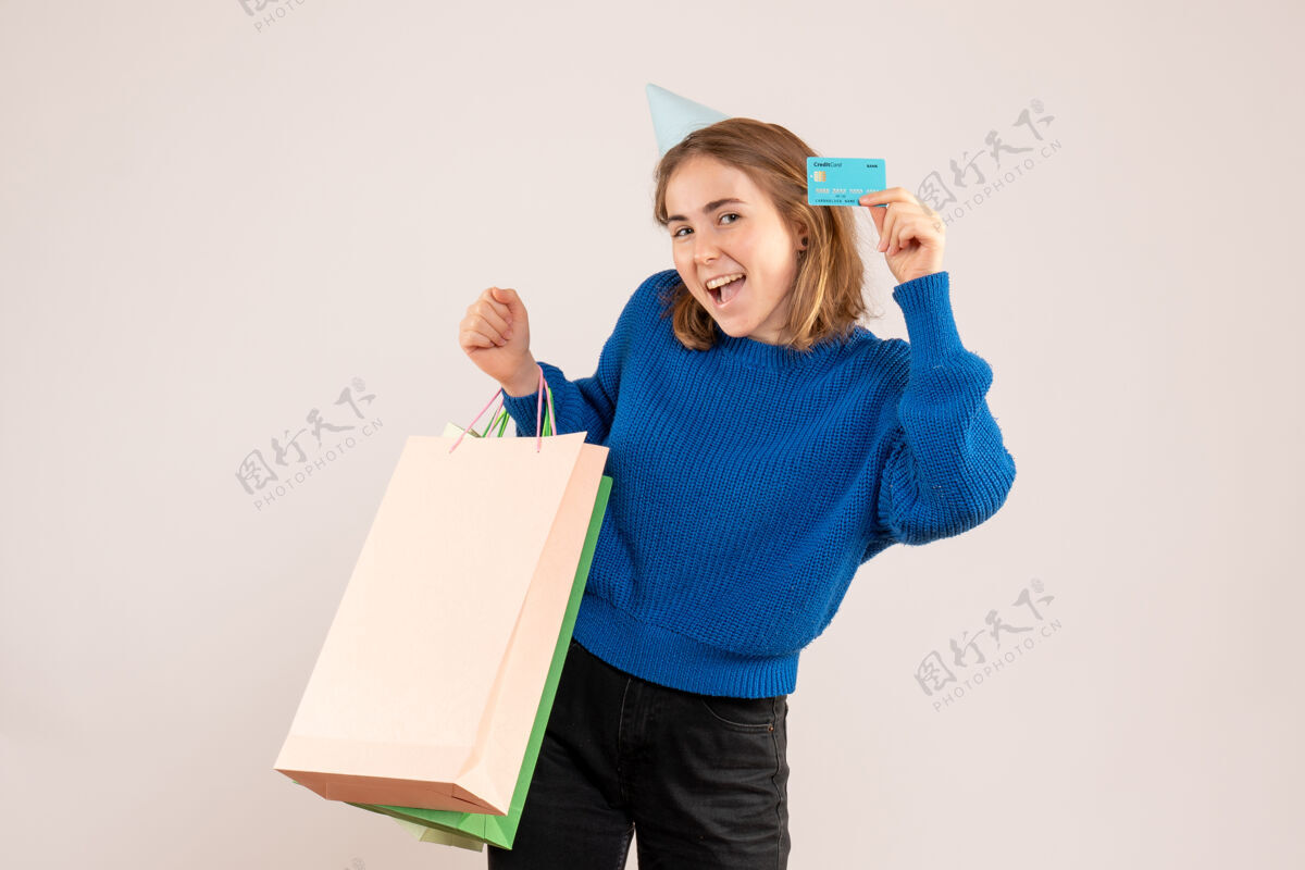 购物年轻女子手持购物包和银行卡上的白色盒子礼物银行