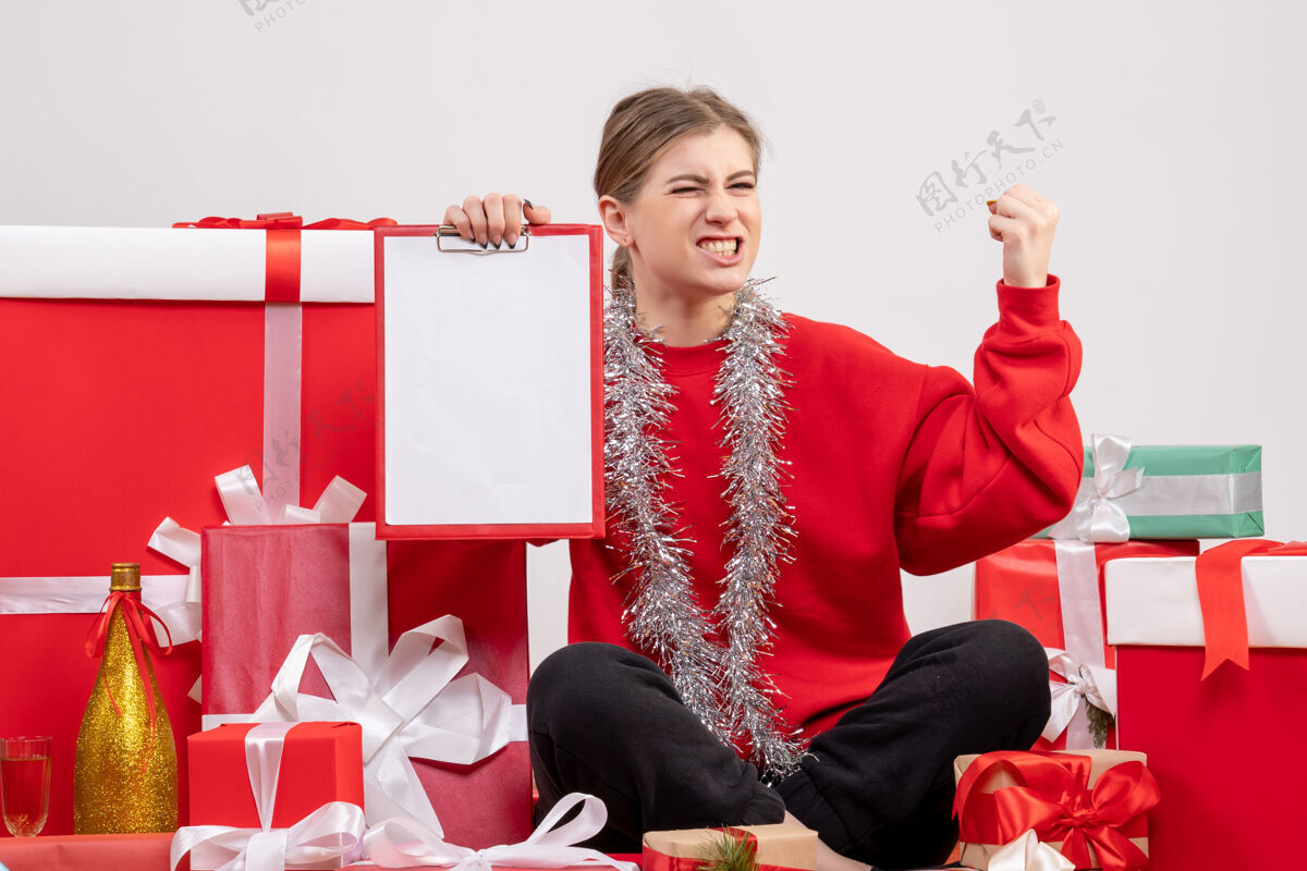 人漂亮的女人围坐在圣诞礼物旁边 白色的纸条围着风景礼物