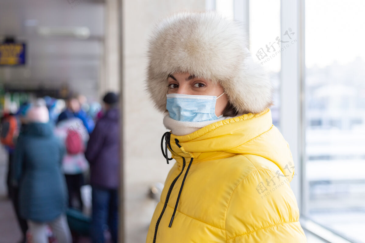 流感年轻女子在火车站戴着防护面具 脸上穿着冬装的乘客Quarantine穿戴保护