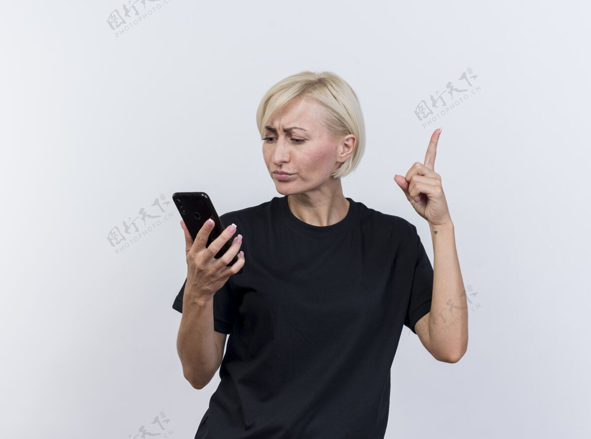 手指令人印象深刻的中年金发斯拉夫妇女手持和看着手机举起手指孤立的白色背景与复制空间中年印象抬高