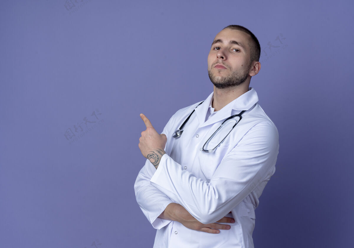 侧面自信的年轻男性医生穿着医用长袍 手持听诊器站在侧视图中 手放在肾脏上 指着紫色的一侧 有复制空间穿着男性医学