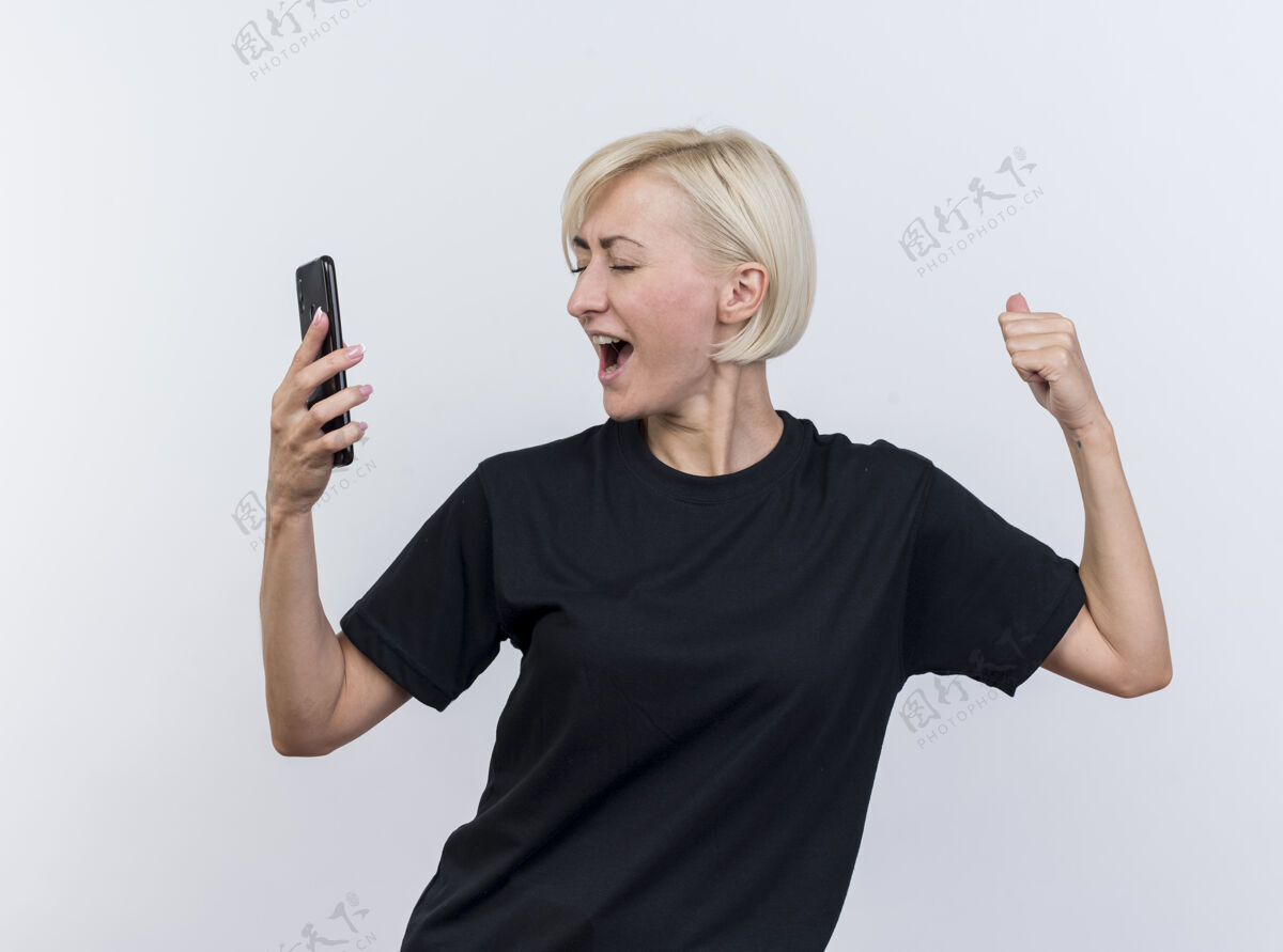中年快乐的中年金发斯拉夫女人拿着手机做着“是”的手势 闭上眼睛隔离在白色背景上快乐闭上电话