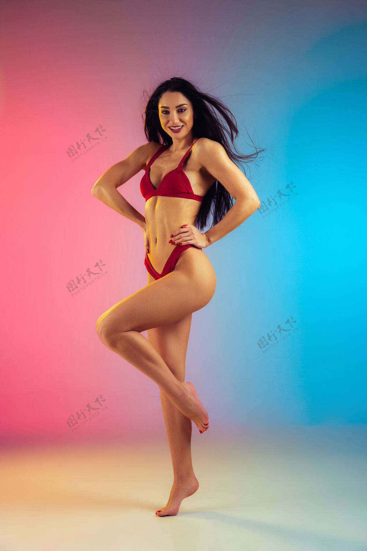 时尚穿着时尚红色泳装的年轻健康运动型白人女性的时尚写真泳装姿势女人