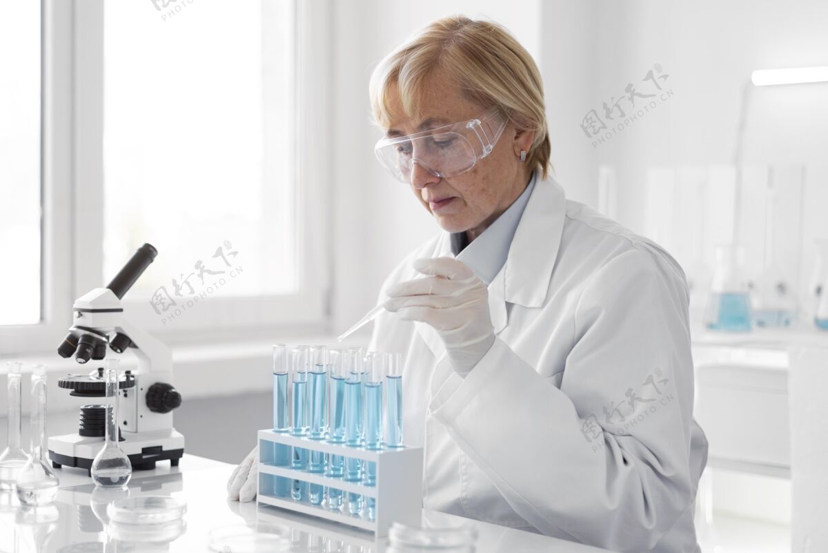 手套在实验室做实验的女人测试试管显微镜