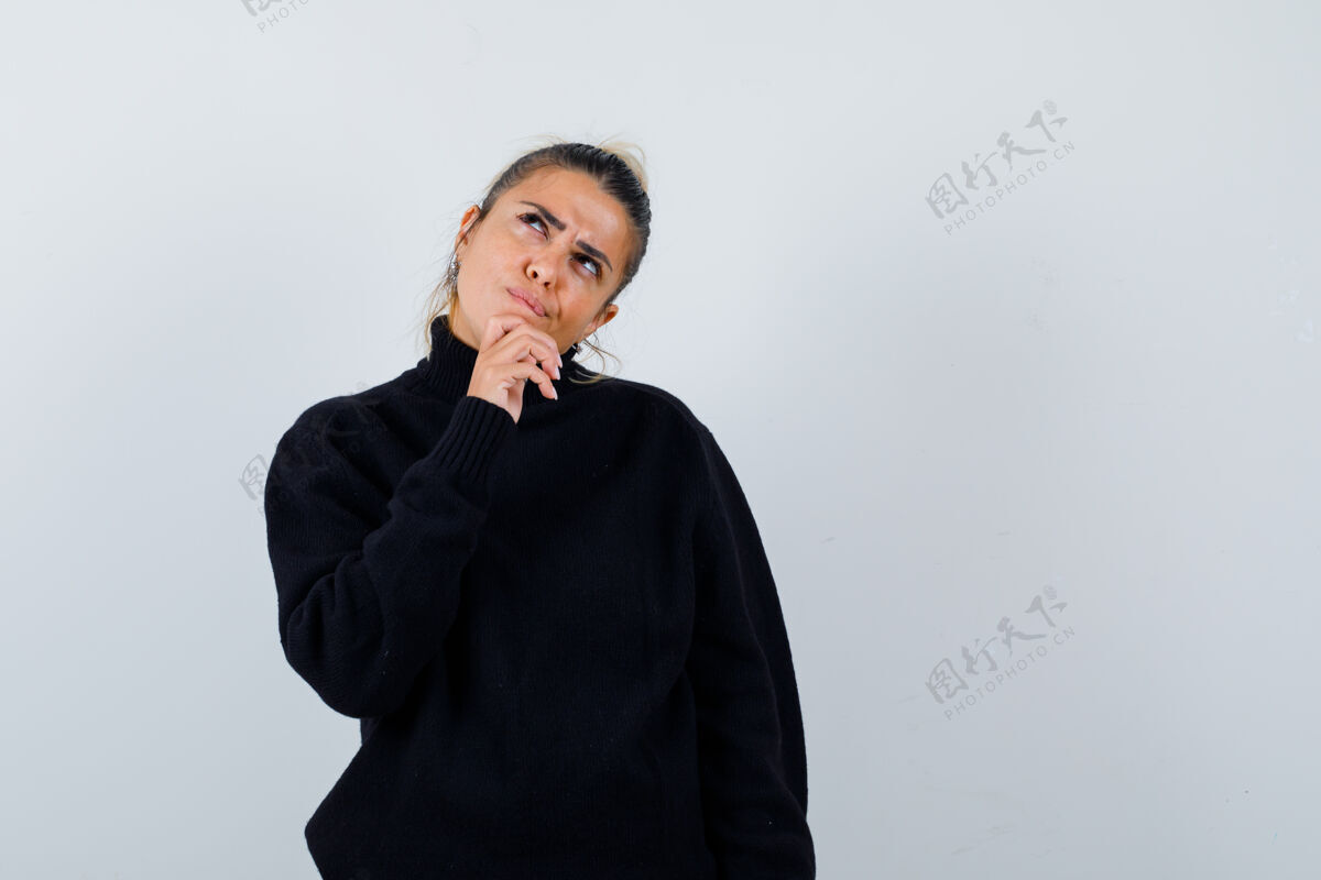 专业年轻的女性穿着高领毛衣站在思考的姿势 看起来沉思前视图沉思工作女士