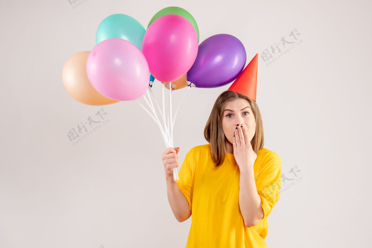 举行手持白色气球的年轻女子年轻女性情绪乐趣
