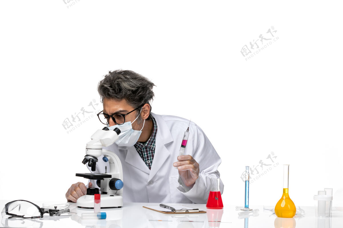 注射正面图身穿白色医疗服的中年科学家手里拿着准备好的注射剂 正在使用显微镜实验室实验专业