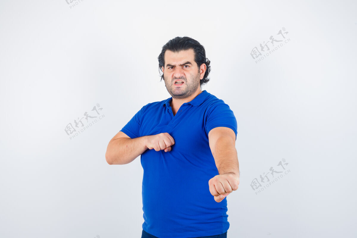 人穿着蓝色t恤 牛仔裤的成熟男人站在打架的姿势 看起来很生气 正面视图站立侵略性压力