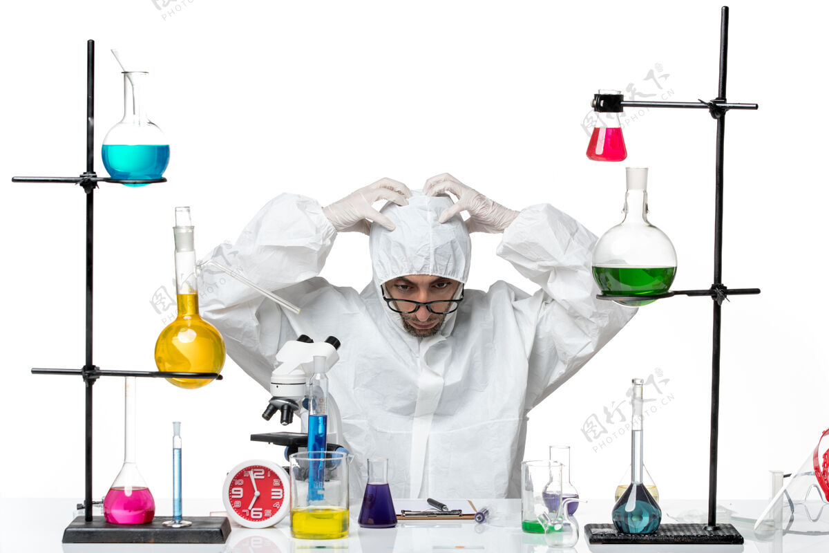 实验室外套正面图穿着特殊防护服的男科学家围坐在办公桌旁 拿着解决方案医疗办公桌特殊