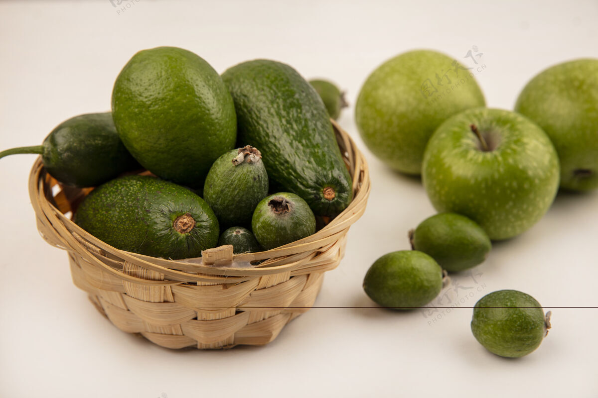 黄瓜顶视图：桶上放着成熟的鳄梨和黄瓜 桶里放着青苹果和白墙上的飞珠小吃美食顶